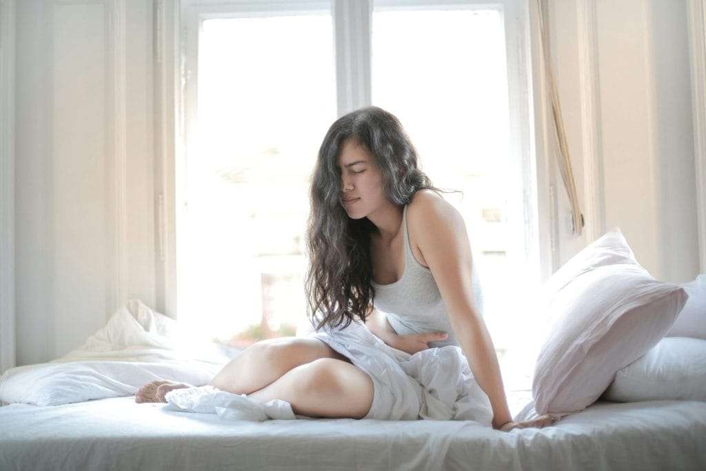 Picture for pain in stomach of a woman on a bed