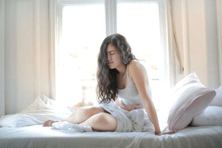 Picture for pain in stomach of a woman on a bed