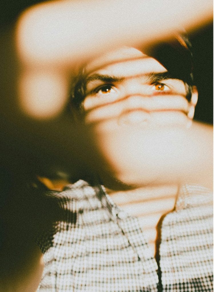 Creative portrait of a man with intriguing light and shadow patterns on his face.
