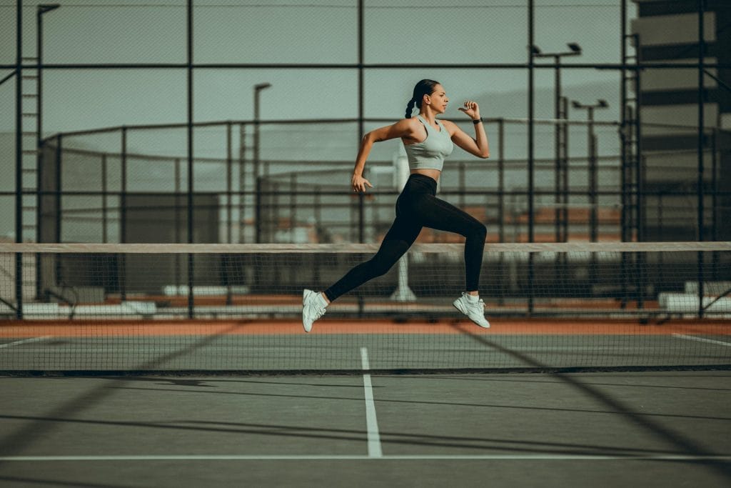 Female Athlete Jumping on a Tennis Court