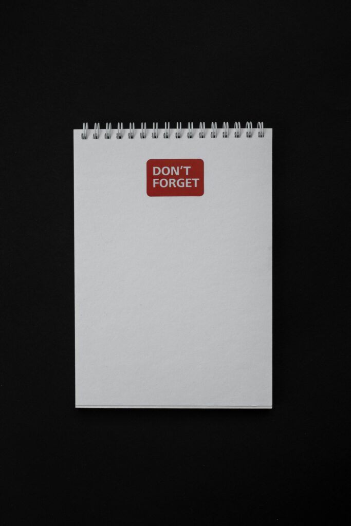 Simple white notebook with a 'Don't Forget' reminder on black background.