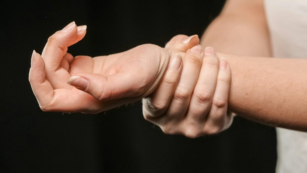 A close-up image of hands grasping a wrist, showcasing human connection and support.