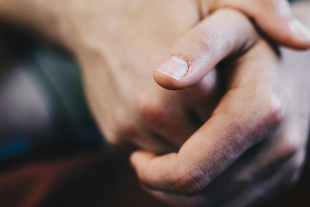 Detailed close-up of a hand with fingers interlocked, creating a contemplative gesture.